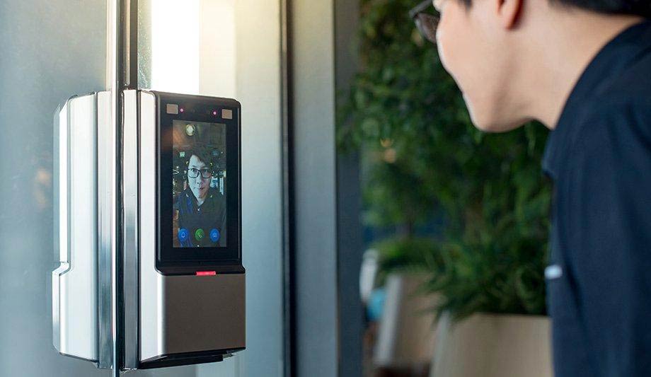 Man standing in front of reader and a camera for facial biometrics